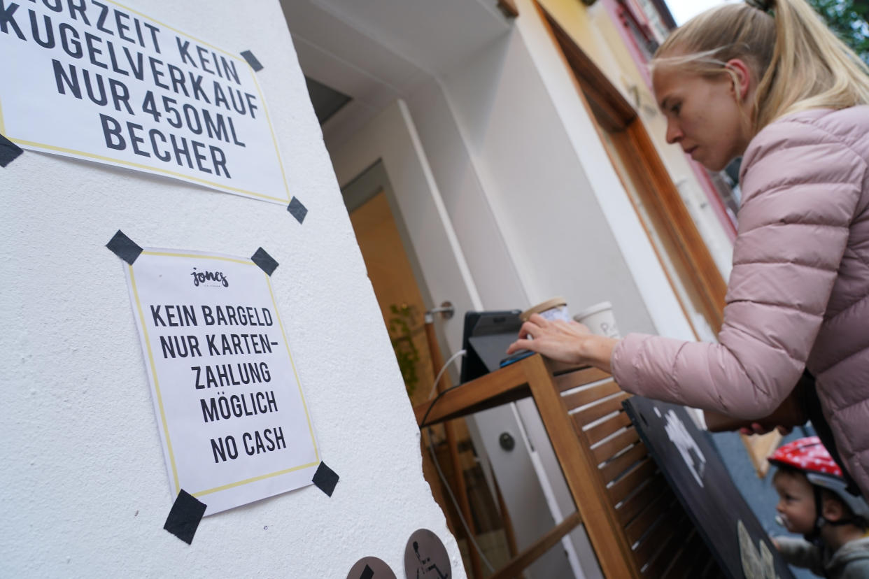 BERLIN, GERMANY - APRIL 29: A sign notifies customers of no cash payments as a customer pays with a credit card at Jones ice cream shop in Schoeneberg district during the novel coronavirus crisis on April 29, 2020 in Berlin, Germany. Many retailers are switching to non-cash payment options as a means to protect staff from infection with the virus. (Photo by Sean Gallup/Getty Images)