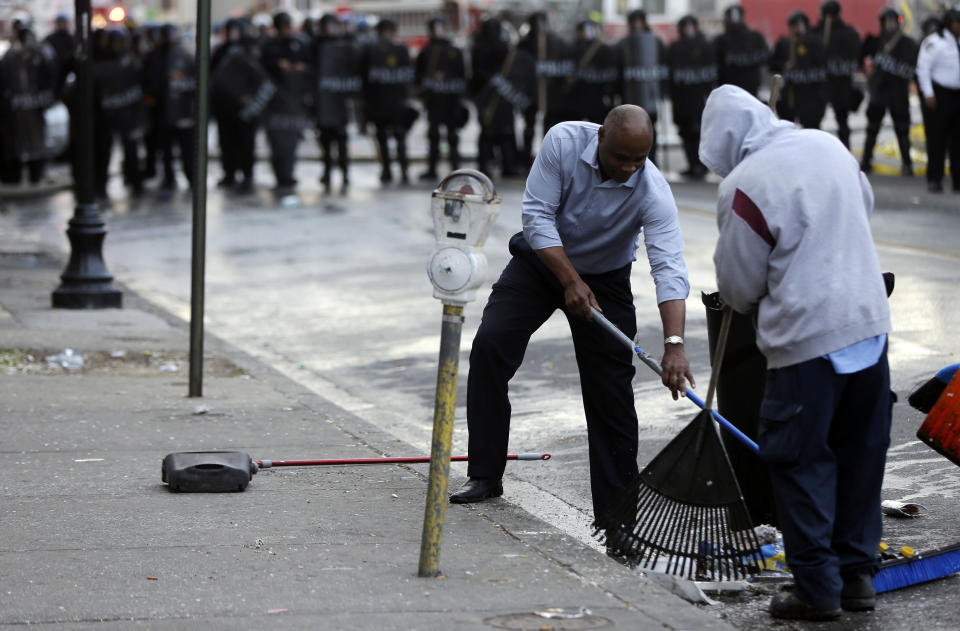 Men clean up during a protest, Monday, April 27, 2015, following the funeral of Freddie Gray in Baltimore.  (AP Photo/Matt Rourke)