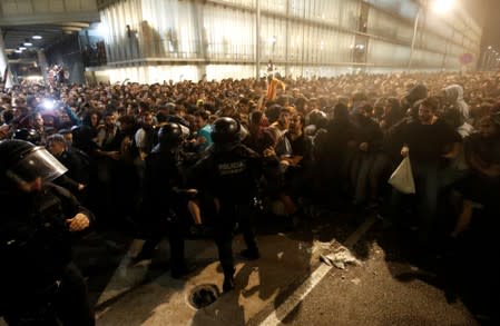 Police officers clash with protesters during a demonstration at the airport, after a verdict in a trial over a banned independence referendum, in Barcelona