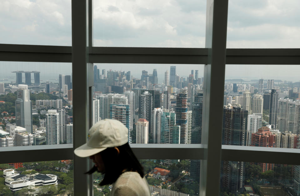A woman passes a view of private residential condominiums on the fringe of the central business district in Singapore. (Photo:REUTERS/Edgar Su)