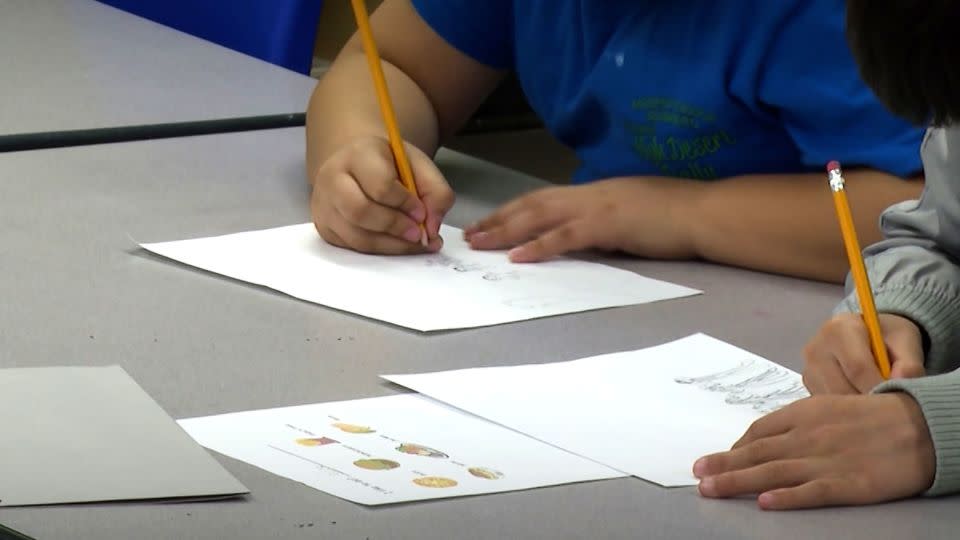 Students write during an English as a new language class at P.S. 111. - CNN