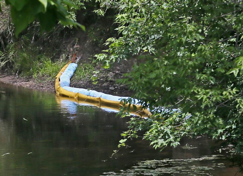 A boon along the shoreline of the Tuscarawas River where the oil spill occurred is seen from on a bridge on Ohio & Erie Canal Towpath Trail near Wolf Creek Trailhead in Barberton.