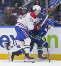 Montreal Canadiens' Arber Xhekaj, left, checks Vancouver Canucks' Sam Lafferty during the first period of an NHL hockey game Thursday, March 21, 2024, in Vancouver, British Columbia. (Darryl Dyck/The Canadian Press via AP)