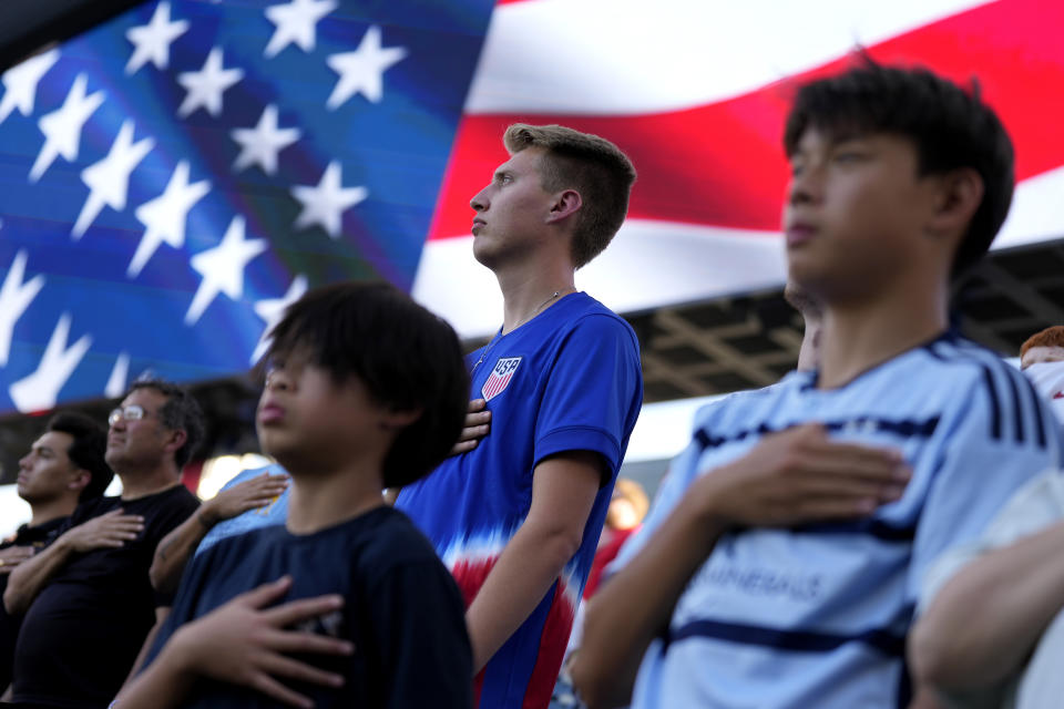 People stand for the national anthem before an international friendly soccer match between the United States and Japan Tuesday, June 11, 2024, in Kansas City, Kan. (AP Photo/Charlie Riedel)