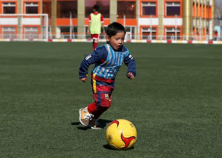 Five year-old Murtaza Ahmadi wears Barcelona's star Lionel Messi shirt made of a plastic bag as he plays soccer at the Afghan Football Federation headquarters in Kabul, Afghanistan February 2, 2016. REUTERS/Omar Sobhani/Files