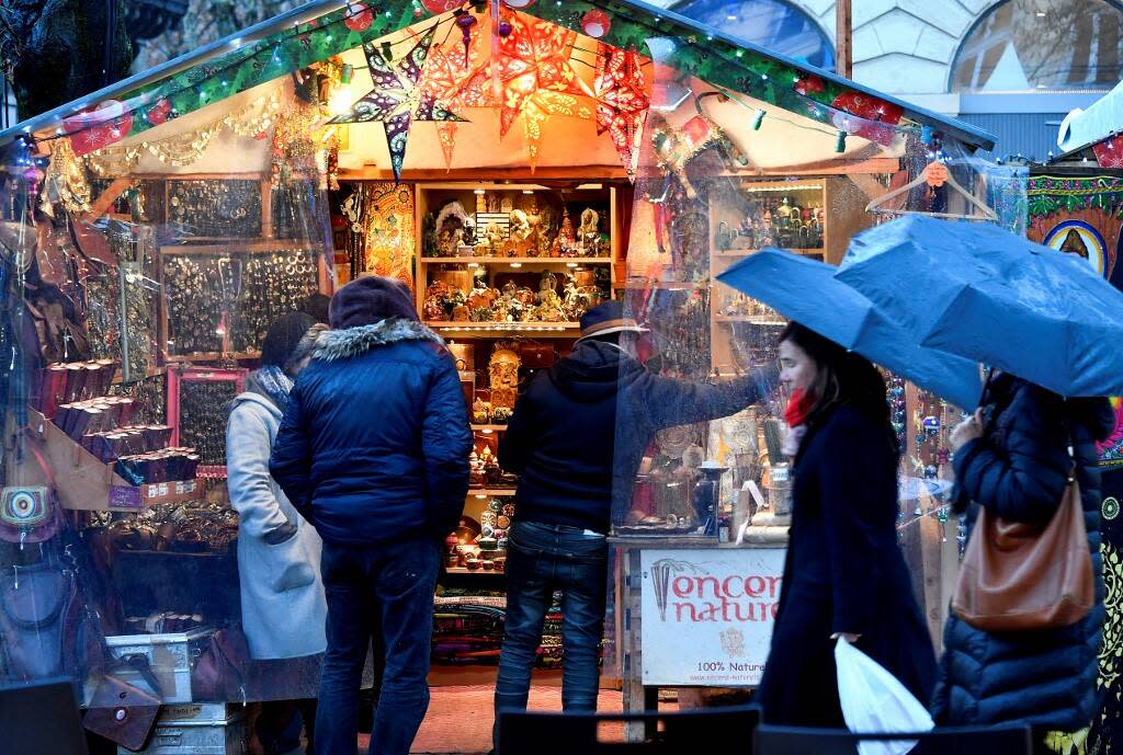 Des visiteurs traversent sous la pluie le marché de Noël de Bordeaux, le 13 décembre 2018.