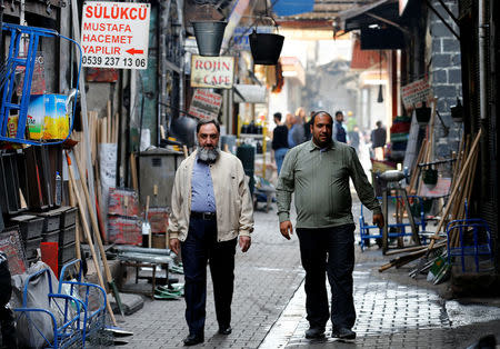 Men walk through a narrow back alley of Sur, an historical district of southeastern province of Diyarbakir, Turkey, March 10, 2017. Picture taken March 10, 2017. REUTERS/Umit Bektas