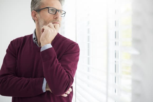 Businessman with hand on chin, deep in thought.