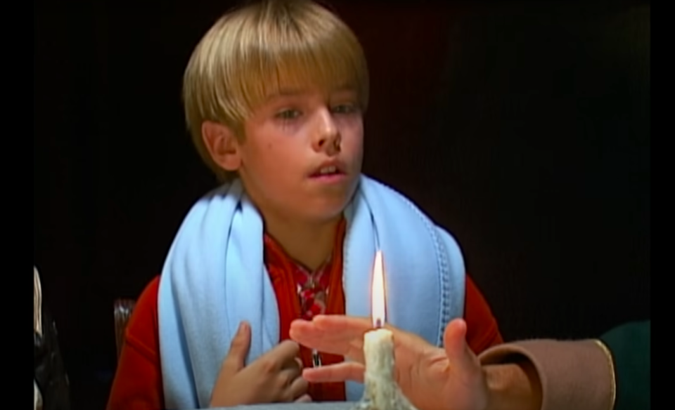 close up of cole's character in front of a candle