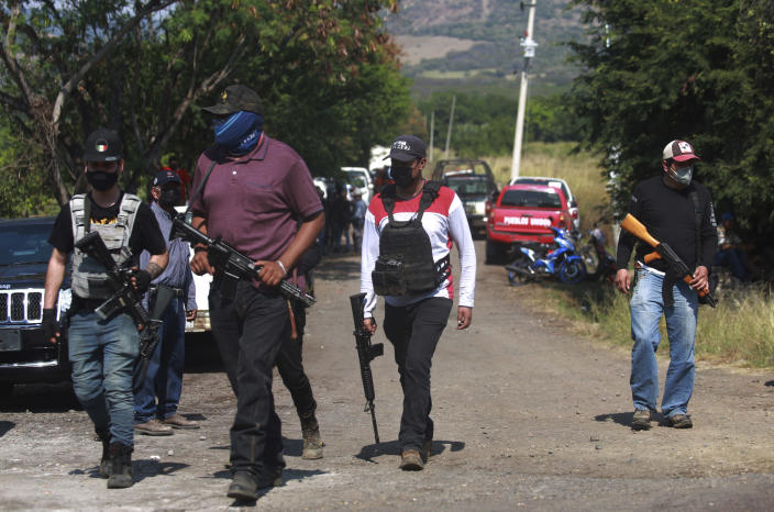 Members of the so-called self-defense group known as United Towns or Pueblos Unidos, gather for a rally in Nuevo Urecho, in the Mexican western state of Michoacan, Saturday Nov. 27, 2021. Extortion of avocado growers in western Mexico has gotten so bad that 500 vigilantes from the "self-defense" group gathered Saturday and pledged to aid police. (AP Photo/Armando Solis)
