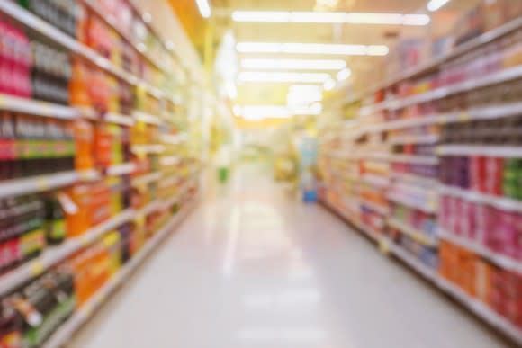 Grocery aisle with soft drink bottles; blurred image effect.