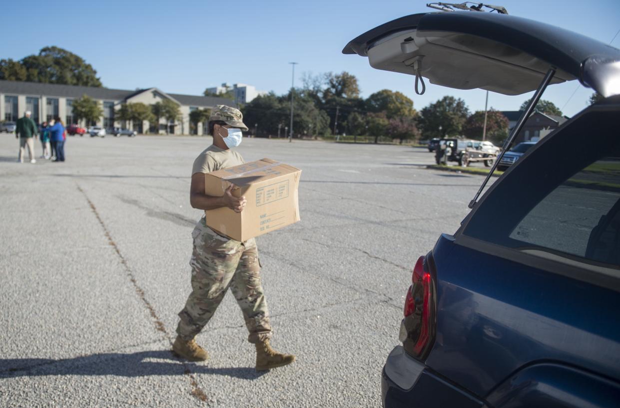 FILE - Army Reserve Staff Sgt. Tiffany Givens carries a box of food from Golden Harvest Food Bank to a waiting vehicle during the annual James Brown Turkey Giveaway in Augusta, Ga., Monday morning November 20, 2020. New research by a UGA professor and others showed about one in eight military families had used a food bank in spring of 2021.