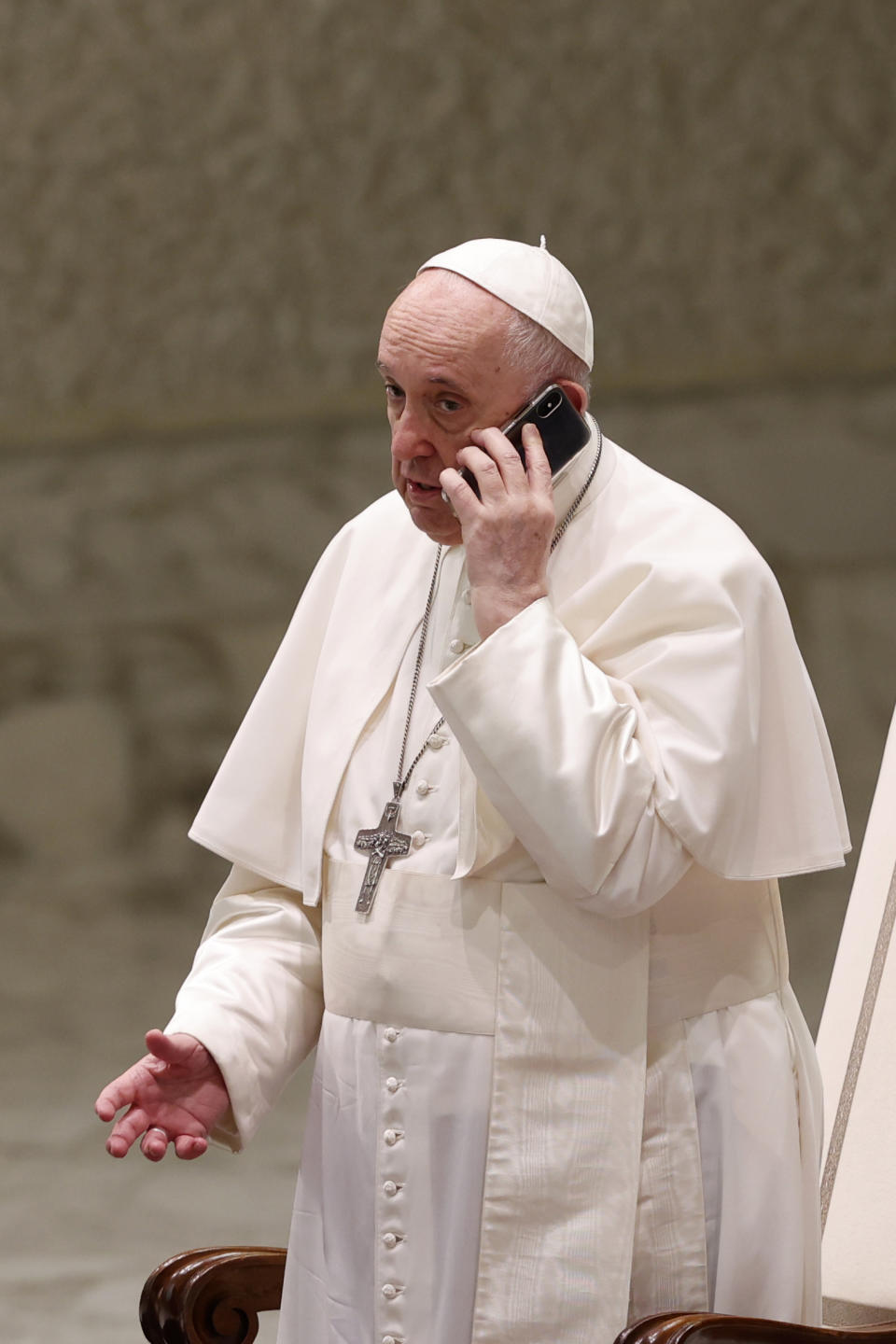 Pope Francis speaks on a cell phone, given to him by his aide Piergiorgio Zanetti, at the end of his weekly general audience in the Paul VI hall at the Vatican, Wednesday, Aug. 11, 2021. (AP Photo/Riccardo De Luca)
