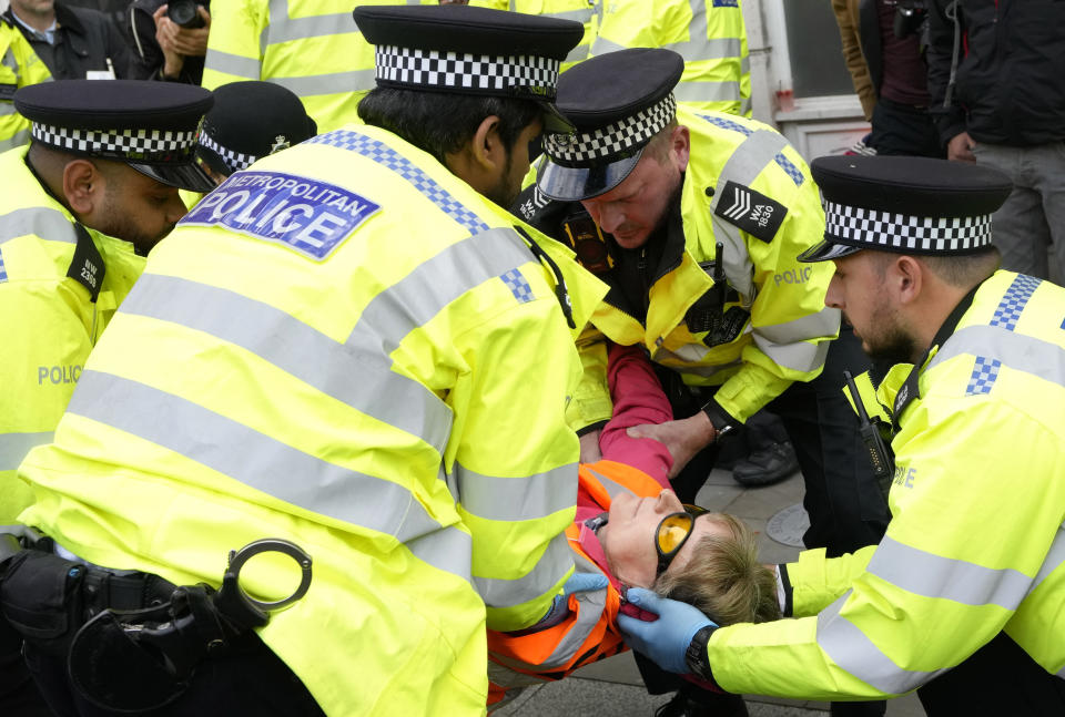 Police officers arrest an activisit from the group Just Stop Oil after they blocked a road in London, Thursday, Oct. 27, 2022, demanding to stop future gas and oil projects from going ahead. (AP Photo/Kirsty Wigglesworth)