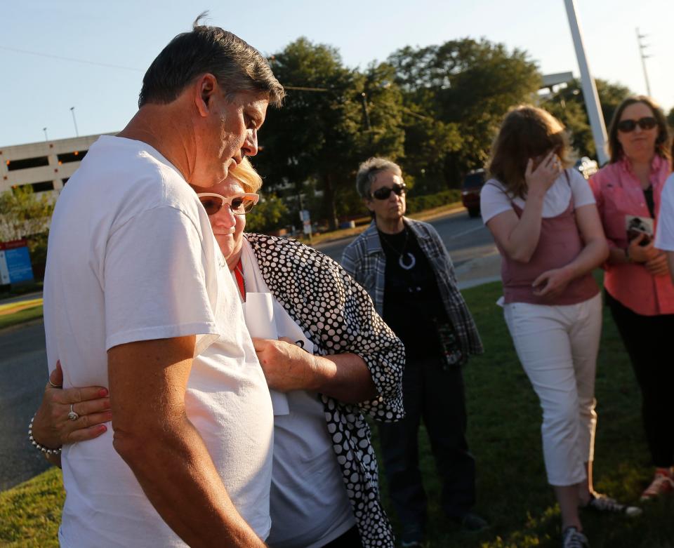 People gather and march in support of Megan Rondini along University Blvd. in Tuscaloosa Friday, September 8, 2017. Russ Yetter hugs his wife Robyn after she spoke. They are relatives of Megan's and traveled from Texas to participate in the march. [Staff Photo/Gary Cosby Jr.]