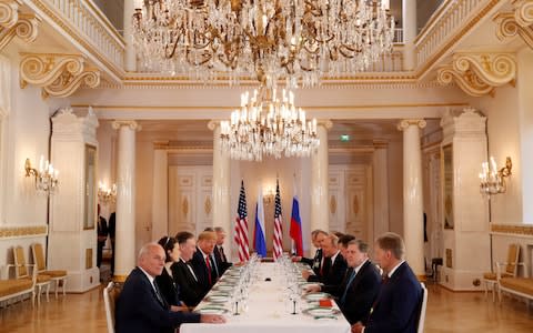 Donald Trump and Vladimir Putin sit opposite each other at an extended bilateral meeting - Credit: Kevin Lamarque/Reuters
