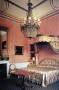 <p>Even the bedrooms are regal, as seen here. This one is decorated with a large chandelier and a silk canopy bed. </p>