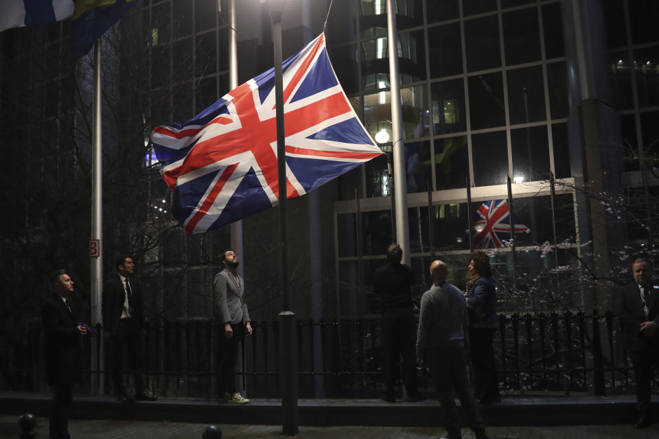 The Union flag is lowered and removed from outside of the European Parliament in Brussels, Friday, Jan. 31, 2020. As the United Kingdom prepared to bring to an end its 47-year EU membership, the bloc's top officials on Friday pledged to continue playing a prominent role despite the loss of a powerful affiliate. (AP Photo/Francisco Seco)