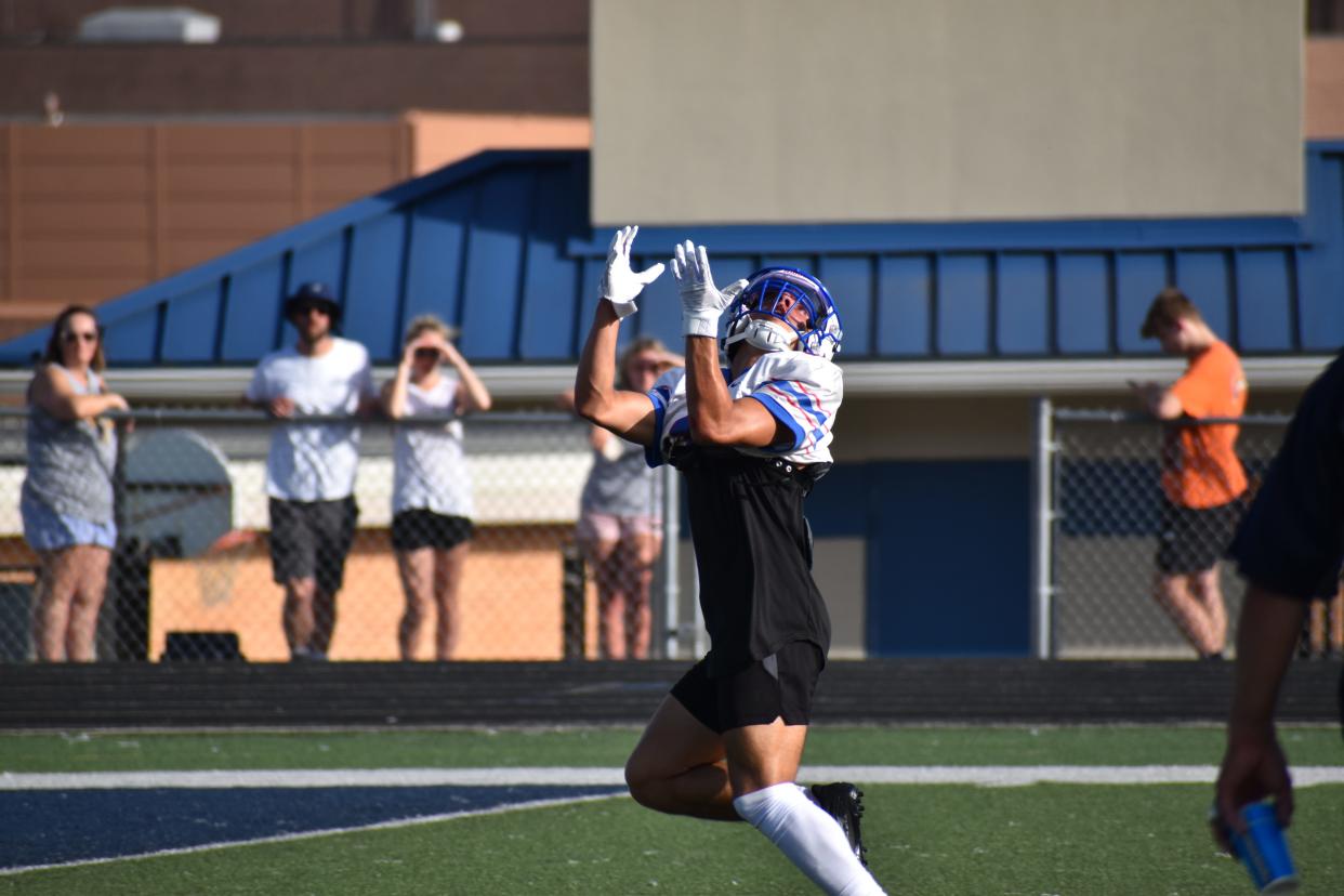 Indian Creek's Gerson Coroa hauls in a deep pass from quarterback Arjun Lothe during the Braves' scrimmage at Mooresville on June 15, 2022.