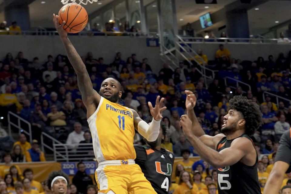Pittsburgh guard Jamarius Burton (11) lays the ball up in front of Miami guard Bensley Joseph (4) and forward Norchad Omier (15) during the second half of an NCAA college basketball game in Pittsburgh, Saturday, Jan. 28, 2023. Pitt won 71-68. (AP Photo/Matt Freed)