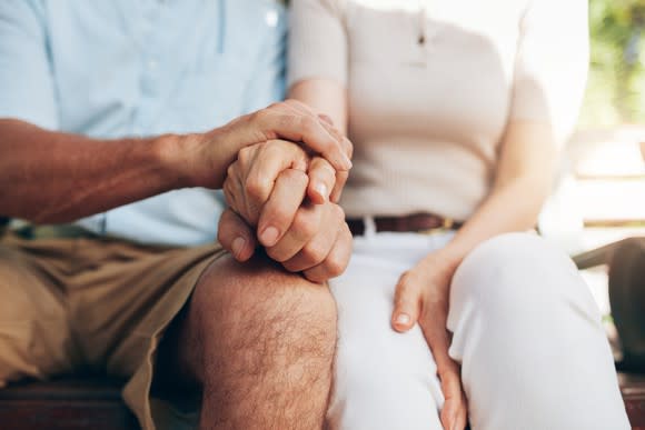 Loving couple sitting together and holding hands