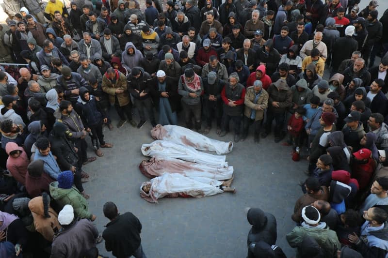 Palestinians perform funeral prayers behind the bodies of those who were killed in Israeli attacks, outside the morgue of Al-Aqsa Hospital in Dair El-Balah. Ali Hamad/APA Images via ZUMA Press Wire/dpa