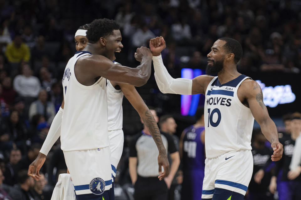 Minnesota Timberwolves guard Mike Conley (10) and guard Anthony Edwards, left, celebrate after a basket and a timeout called for tby the Sacramento Kings during the second half of an NBA basketball game in Sacramento, Calif., Saturday, Dec. 23, 2023. The Timberwolves won 110-98. (AP Photo/José Luis Villegas)