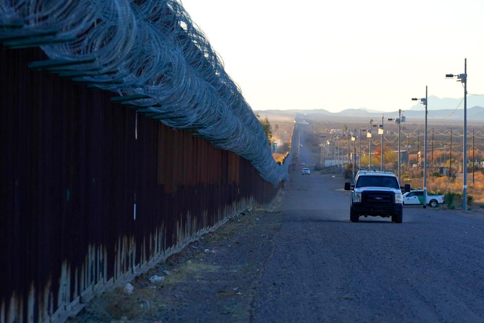 FILE - A U.S. Border Patrol vehicle drives along the border fence at the U.S.-Mexico border wall, on Dec. 15, 2020, in Douglas, Ariz. Authorities are investigating the cause of death of a female migrant whose leg was entrapped while using a climbing harness and ended up hanging upside down off the border wall in eastern Arizona. U.S. Customs and Border Protection officials offered few details, but the local sheriff's office said the woman was a 32-year-old Mexican who was attempting to cross the wall Monday, April 11, 2022 near Douglas, Arizona. Her name was not released. (AP Photo/Ross D. Franklin, File)