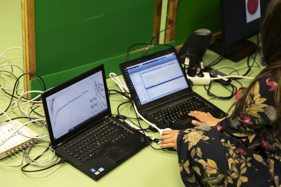 The researchers measure the dogs' brain activity during an experiment at the department of Ethology of the Eotvos Lorand University in Budapest, Hungary, on Wednesday, March 27, 2024. A new study in Hungary has found that beyond being able to learn how to perform commands, dogs can learn to associate words with specific objects — a relationship with language called referential understanding that had been unproven until now. (AP Photo/Denes Erdos)