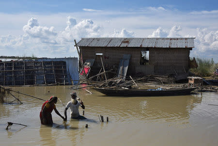 People wade through flooded waters at a village in Morigaon district in Assam, India August 20, 2017. REUTERS/Anuwar Hazarika