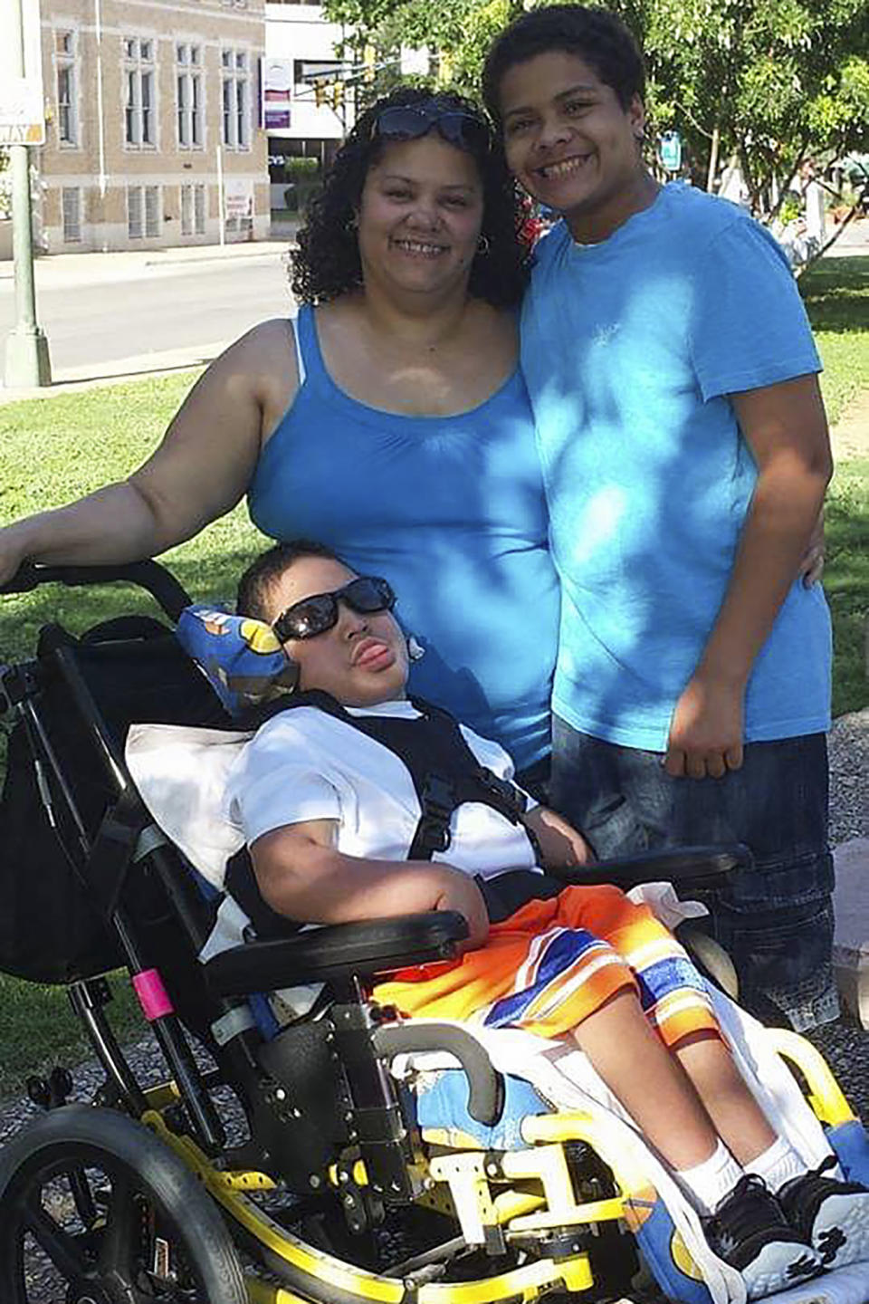 This 2014 photo provided by Itza Pantoja shows Pantoja with her sons Dylan Cruz-Pantoja, left, and Adrik Cruz-Pantoja at a park near The Children's Hospital of San Antonio in Texas. After Itza Pantoja's severely disabled son died at the age of 16, she made it her mission to ensure that the wheelchairs, beds and other equipment and supplies that had helped him got to others who needed them. (Itza Pantoja via AP)