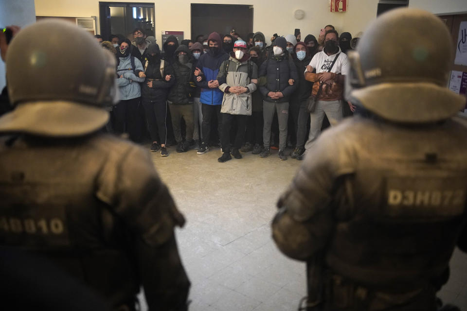 Supporters surround rap singer Pablo Hasél as police officers arrive to arrest him at the University of Lleida, Spain, Tuesday, Feb. 16, 2021. A rapper in Spain and dozens of his supporters have locked themselves inside a university building in the artist's latest attempt to avoid a prison sentence for insulting the monarchy and praising terrorism. (AP Photo/Joan Mateu)