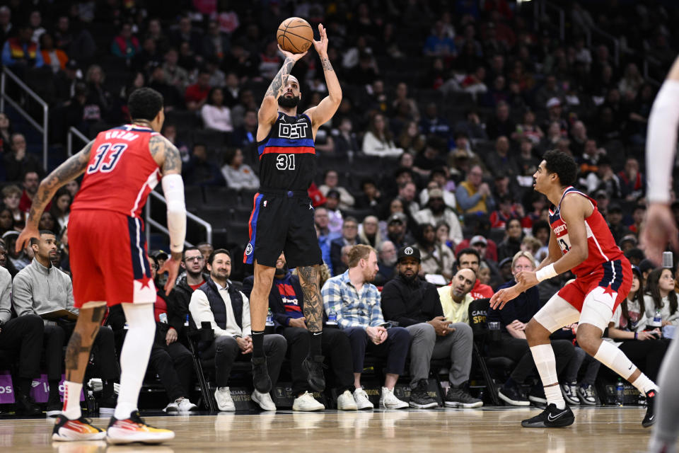 Detroit Pistons guard Evan Fournier (31) shoots against Washington Wizards guard Jordan Poole, right, and forward Kyle Kuzma (33) during the first half of an NBA basketball game Friday, March 29, 2024, in Washington. (AP Photo/Nick Wass)