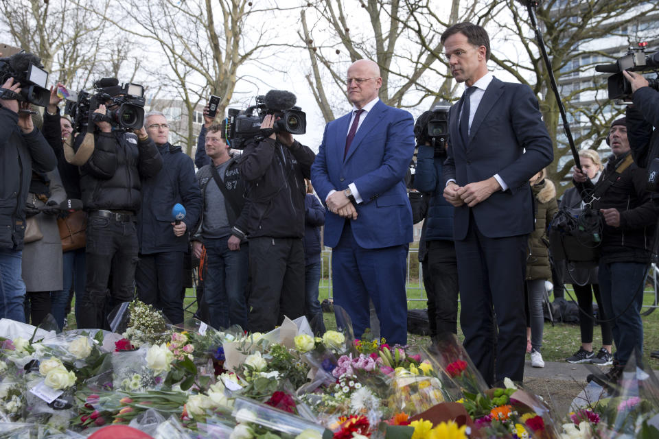 Dutch Prime Minister Mark Rutte, right, and Justice Minister Ferd Grapperhaus, center, observe a moment of silence after putting flowers at a makeshift memorial for victims of a shooting incident in a tram in Utrecht, Netherlands, March 19, 2019. (Photo: Peter Dejong/AP)