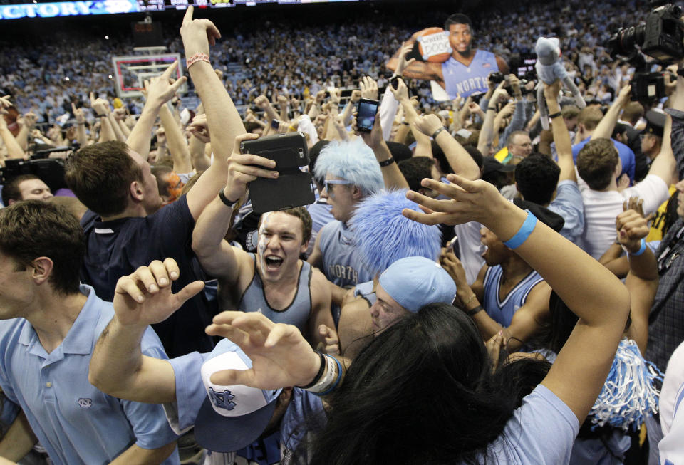 Fans rush the playing court following North Carolina's 74-66 win over Duke in an NCAA college basketball game in Chapel Hill, N.C., Thursday, Feb. 20, 2014. (AP Photo/Gerry Broome)