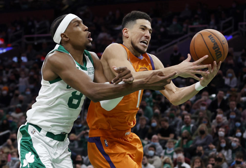 Boston Celtics guard Josh Richardson (8) and Phoenix Suns guard Devin Booker (1) battle for a rebound during the second half of an NBA basketball game, Friday, Dec. 31, 2021, in Boston. (AP Photo/Mary Schwalm)