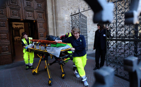 Medical personnel walks out of the Santa Croce Basilica after the 52-year-old Spanish tourist's death - Credit: AP