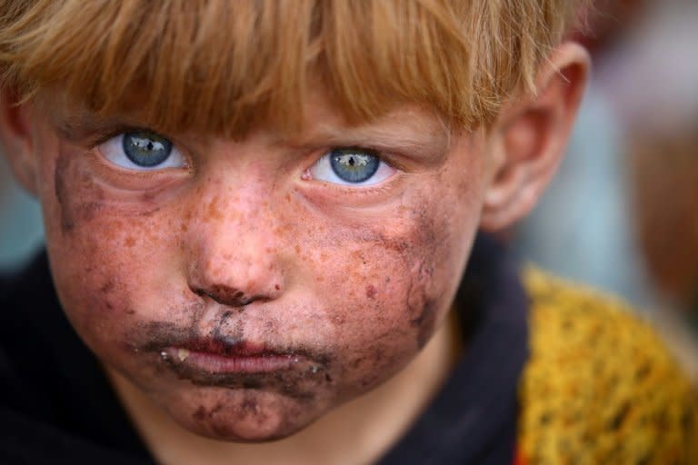 A displaced Syrian child, who fled the area surrounding the Islamic State group stronghold of Raqa, is photographed at a temporary camp in the village of Ain Issa