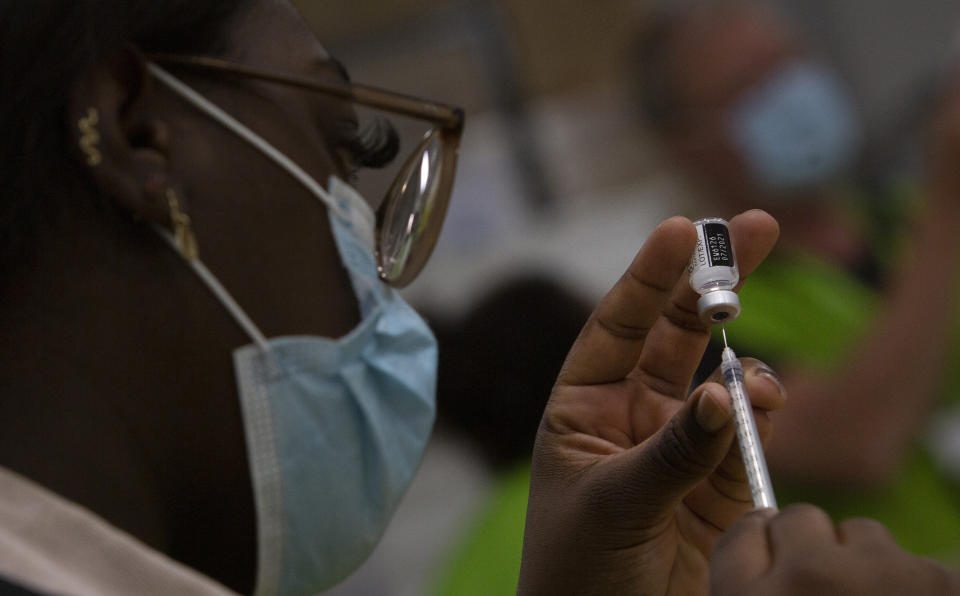 FILE - In this Friday, April 30, 2021 file photo, a pharmacist fills a syringe with a vial of the Pfizer COVID-19 vaccine at the Vaccine Village in Antwerp, Belgium. The European Union cemented its support for Pfizer-BioNTech and its novel COVID-19 vaccine technology Saturday, May 8, 2021 by agreeing to a massive contract extension for a potential 1.8 billion doses through 2023. The new contract, which has the backing of the EU member states, will entail not only the production of the vaccines, but also making sure that all the essential components should be sourced from the EU. (AP Photo/Virginia Mayo, File)