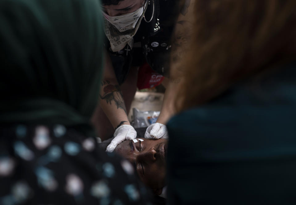 A man is tended to after sustaining an injury from a projectile shot by police outside the 3rd Police Precinct building in Minneapolis, Minn., on May 27, 2020. | Stephen Maturen—Getty Images