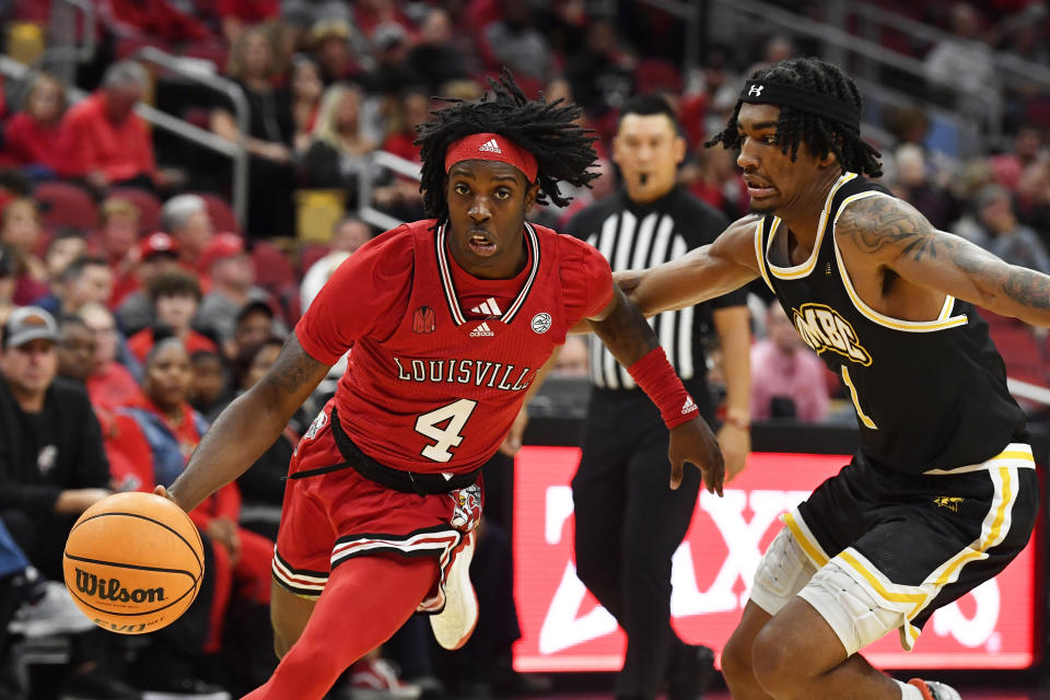 Louisville guard Ty-Laur Johnson (4) drives past Maryland Baltimore County guard Ace Valentine (1) during the second half of an NCAA college basketball game in Louisville, Ky., Monday, Nov. 6, 2023. Louisville won 94-93. (AP Photo/Timothy D. Easley)