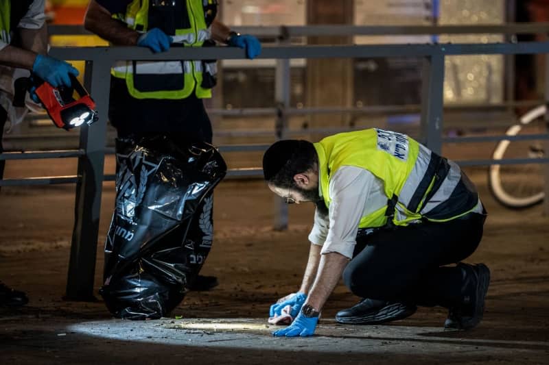 Israeli forensic officers work at the scene of a shooting in the mixed Arab-Jewish neighborhood of Jaffa. Six people were killed in a shooting on Jerusalem Boulevard, according to Israeli police. Ilia Yefimovich/dpa