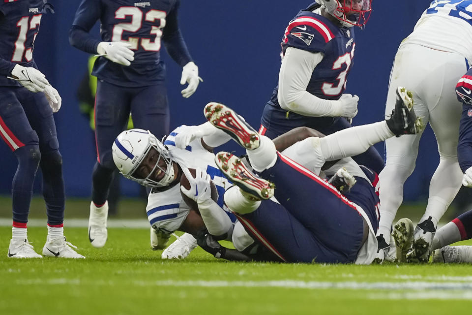 Indianapolis Colts running back Zack Moss (21) is tackled in the first half of an NFL football game against the New England Patriots in Frankfurt, Germany Sunday, Nov. 12, 2023. (AP Photo/Martin Meissner)