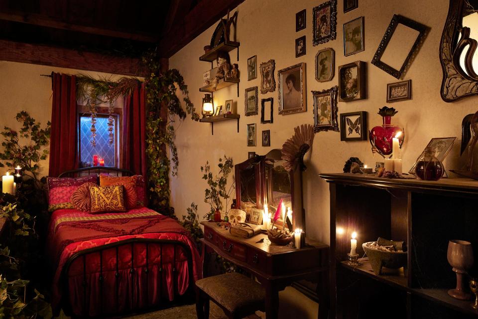 A recreation of Mary Sanderson's bed is surrounded by ivy, photos, candles and decorative skull.