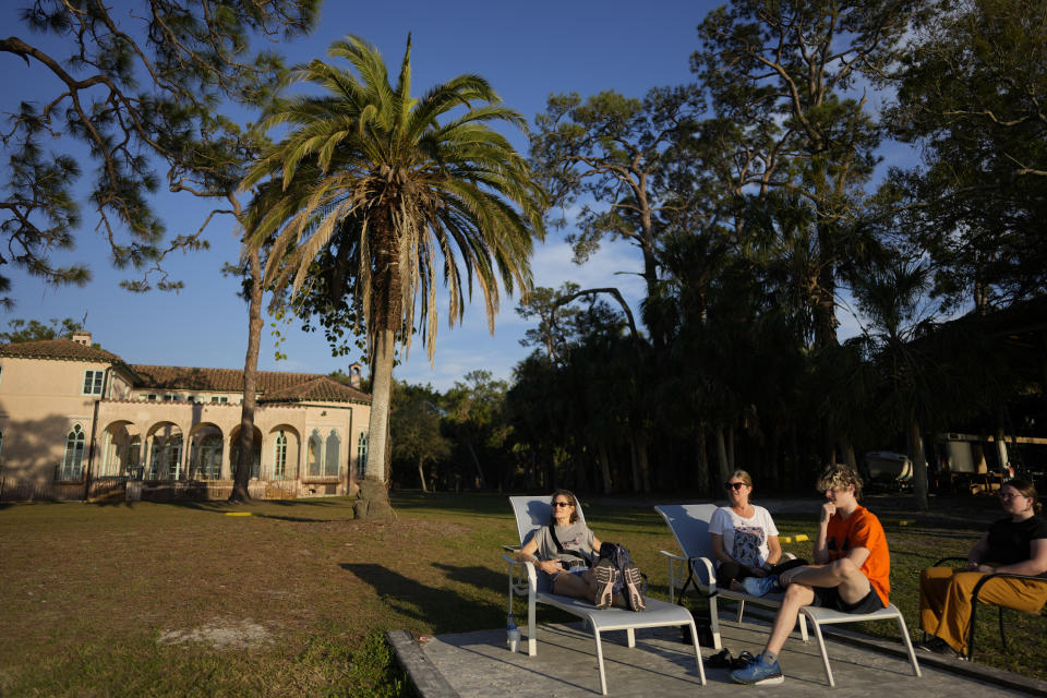 Joyce White, third from left, sits with her daughter Lola, right, son Liam, second right, and friend Eliana Salzhauer, on the waterfront at New College of Florida, where Lola is a third-year biology major with plans to be a veterinarian, Wednesday, March 1, 2023, in Sarasota, Fla. "We found this little school that was perfect for Lola," said White, whose daughter is autistic, has ADHD, and excelled at school, but found it very stressful. "Now it feels like everything has blown up." (AP Photo/Rebecca Blackwell)