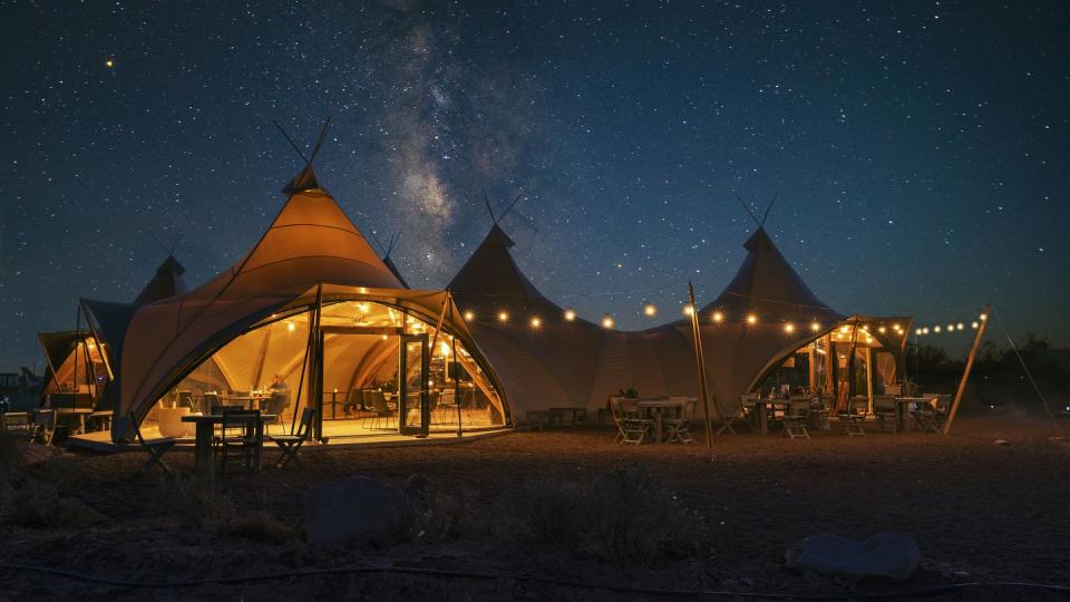 an illuminated tent under the stars at the grand canyon under canvas is a good housekeeping pick for best family vacation destinations