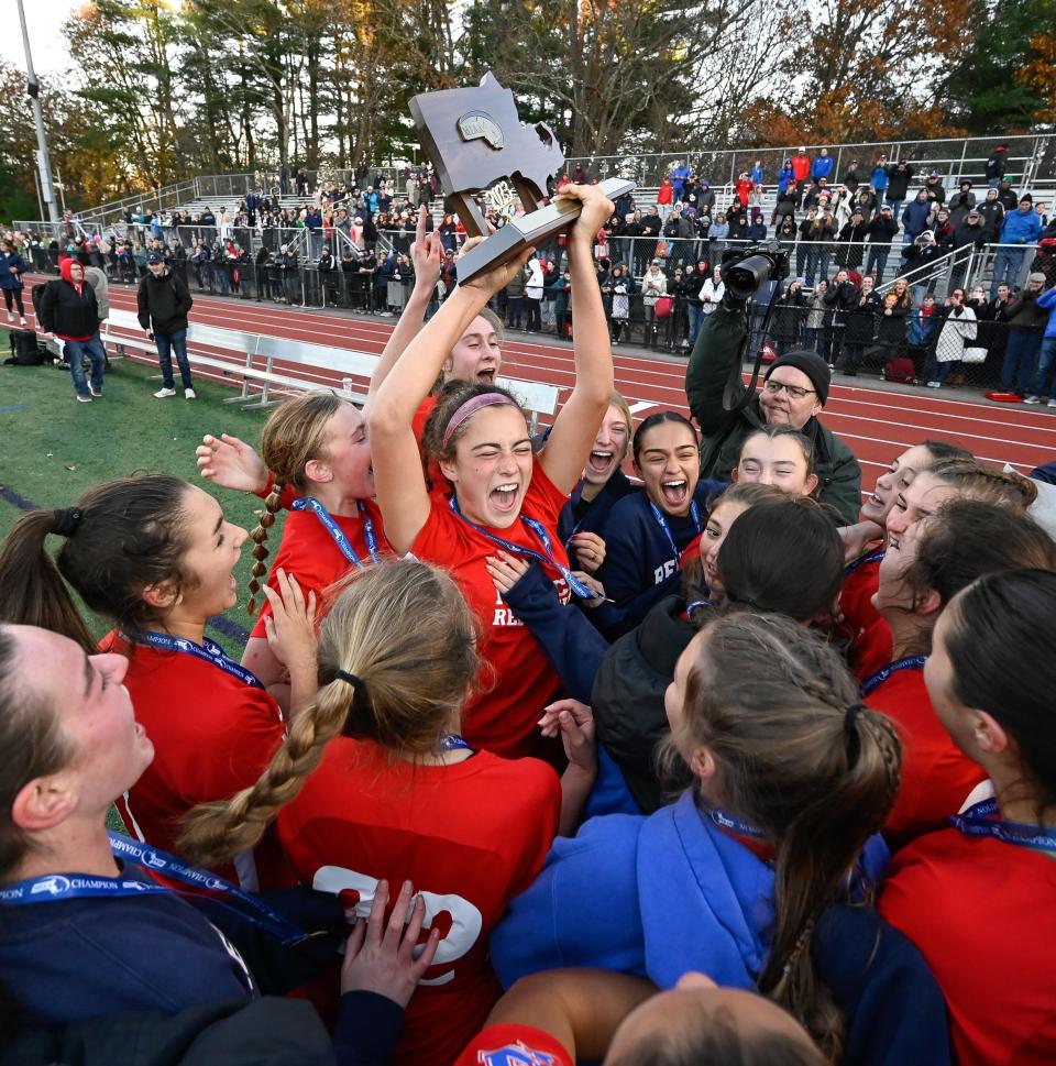 Natick senior captain Kaitlyn LeBrun holds up the championship trophy after the Redhawks beat Bishop Feehan 2-0 in the Division 1 state final.