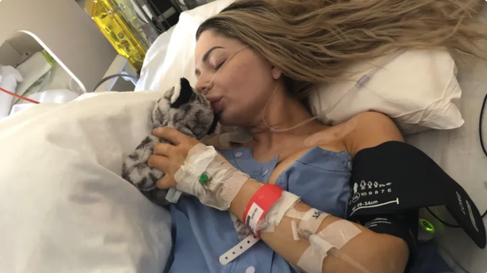 Nikita Piil lies in a hospital bed holding a teddy where she continues to fight for her life.