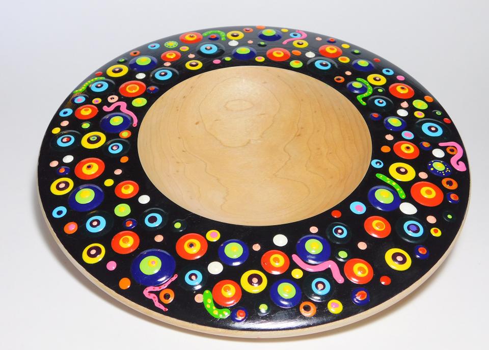 Gary Hawley, of Arlington, turns hardwood on a lathe. This bowl is embellished with an abstract design of thick, brilliantly colored acrylic paint.
