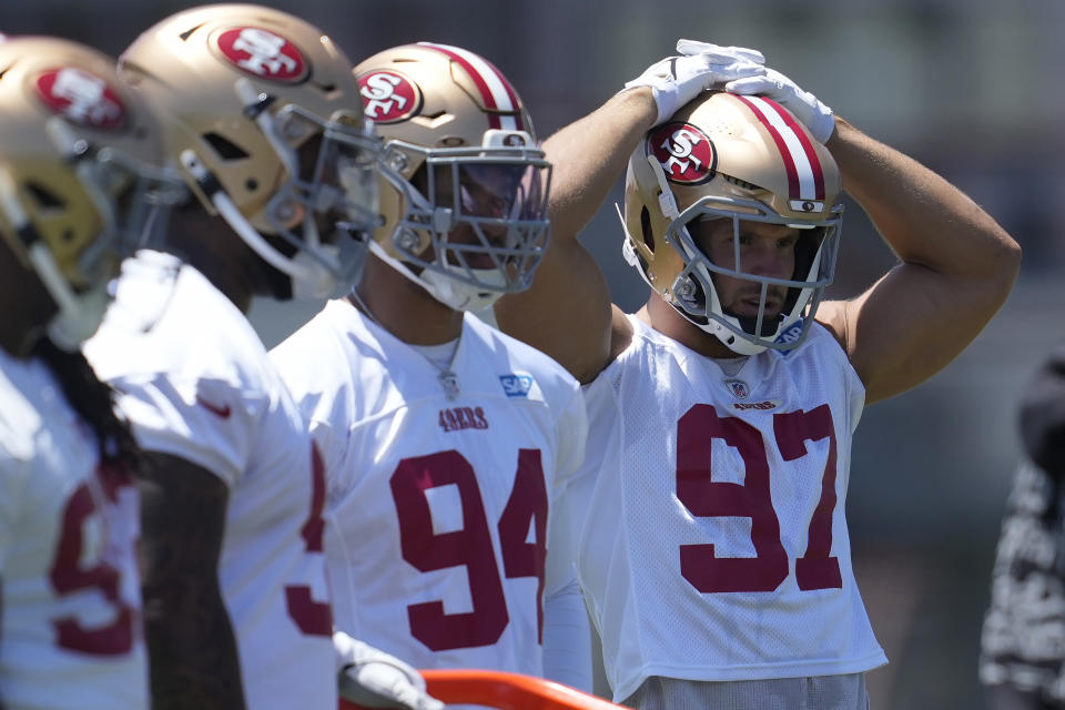 San Francisco 49ers' Yetur Gross-Matos (94), Nick Bosa (97) and teammates wait to run drills during NFL football practice in Santa Clara, Calif., Tuesday, May 21, 2024. (AP Photo/Jeff Chiu)